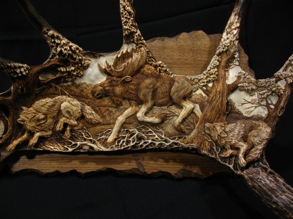 16. 'Moose and Wolves' by Dmitry Gorodetsky (carved and stained moose antler - 54cm x 27cm)