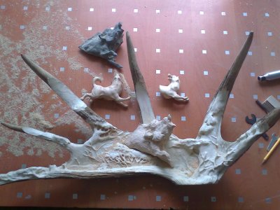 Phase 4 - The two laikas are refined and the wild boar is roughed out in wood. Further detail of trees and bushes are added to the moose antler background. (Dmitry Gorodetsky mixed media moose antler sculpture, in progress)