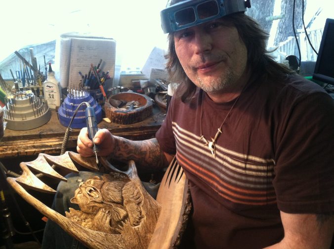 Jack Brown working on and antler sculpture with his favourite tool, the RAM Micromotor. He is wearing an Optimizer and you can see various burrs in the background. Also note the book he uses to keep track of his finished carvings.
